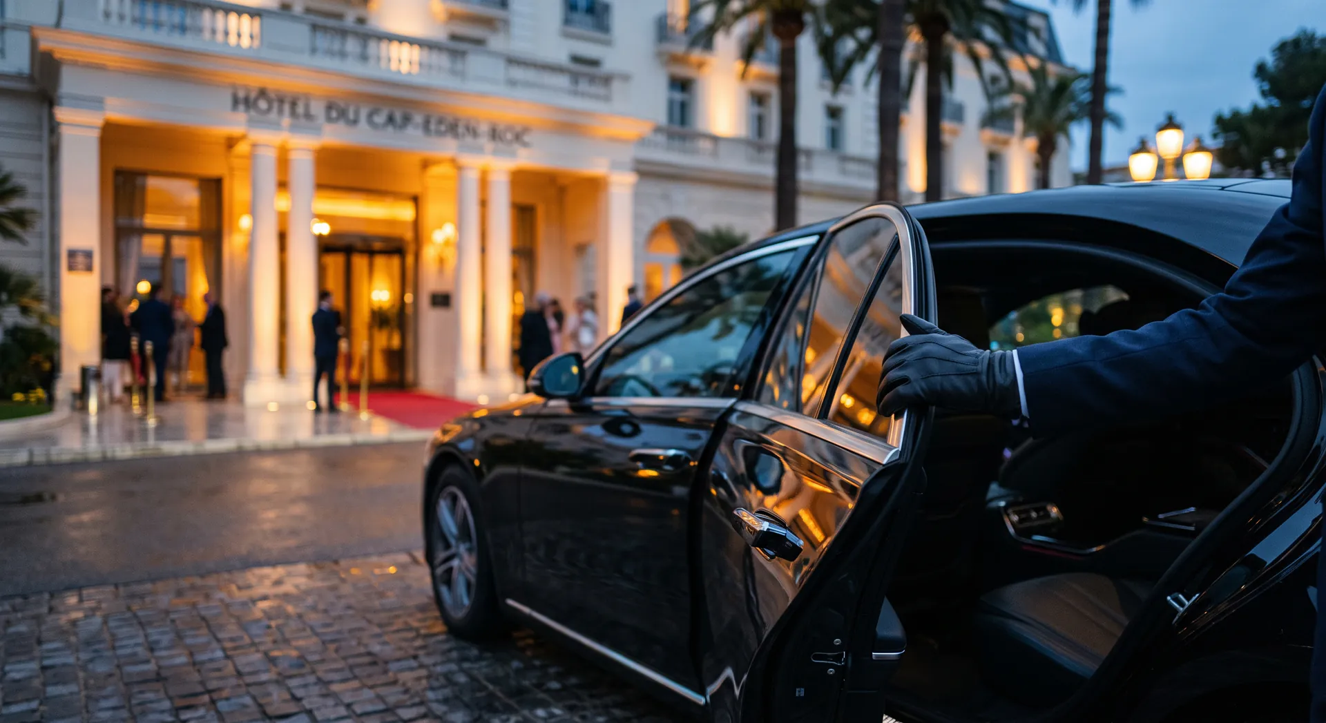 Rear door of a black sedan held open outside a Croisette hotel